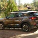 A bronze 2022 Chevy Trailblazer is shown from the side driving past a lake after leaving a Chevy dealer in Allentown, PA.