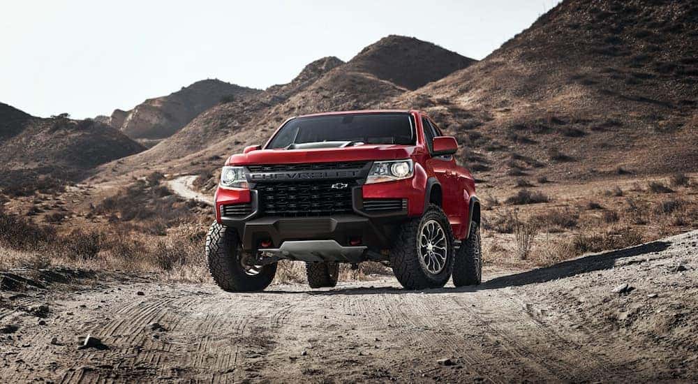A red 2022 Chevy Colorado ZR2 is shown parked on a remote desert road.