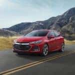 A red 2019 Chevy Cruze RS is shown driving on a sunny day.