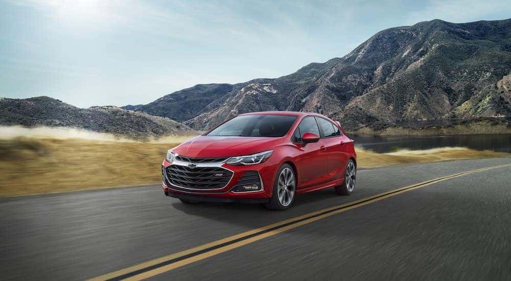 A red 2019 Chevy Cruze RS is shown driving on a sunny day.
