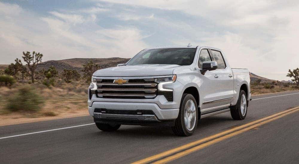 A 2022 Chevy Silverado 1500 High country is shown from the front while it drives down a desert road after leaving a Chevy dealer Allentown PA.