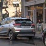 A grey 2023 Chevy Bolt EUV is shown from behind on a city street.