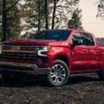 A red 2023 Chevy Silverado 1500 Z71 for sale is shown parked in an open dirt lot.