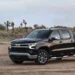 A black 2022 Chevy Silverado 1500 LT is shown from the side while parked off-road.
