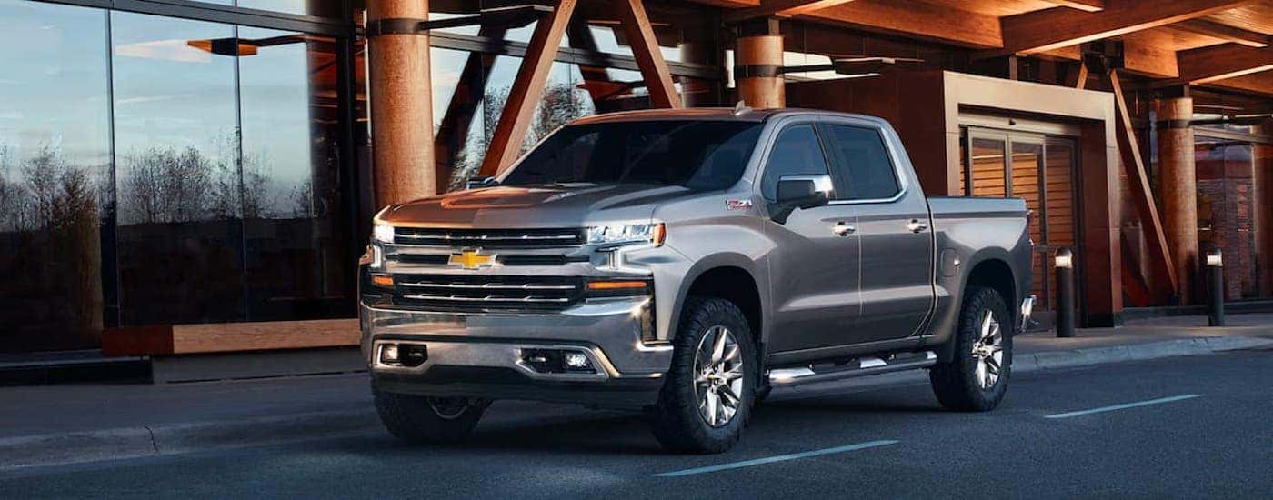 A silver 2021 Chevy Silverado 1500 is shown from the front at an angle after leaving a dealer that has a used Chevy Silverado for sale.