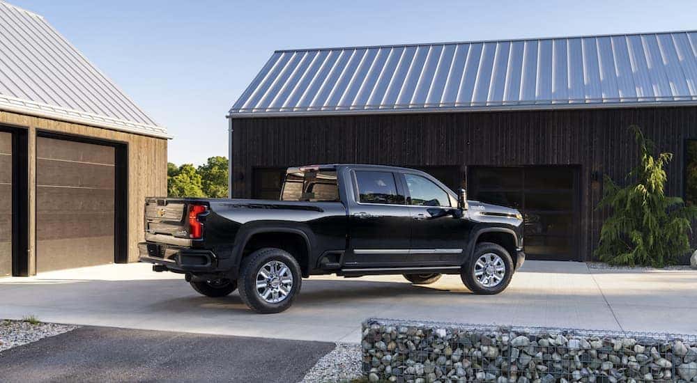 A black 2024 Chevy Silverado 2500 HD is shown from the side while parked.