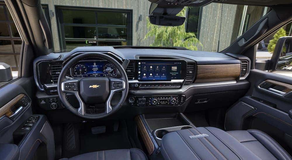 The black interior of a 2024 Chevy Silverado 2500 HD High Country is shown from the driver's seat.