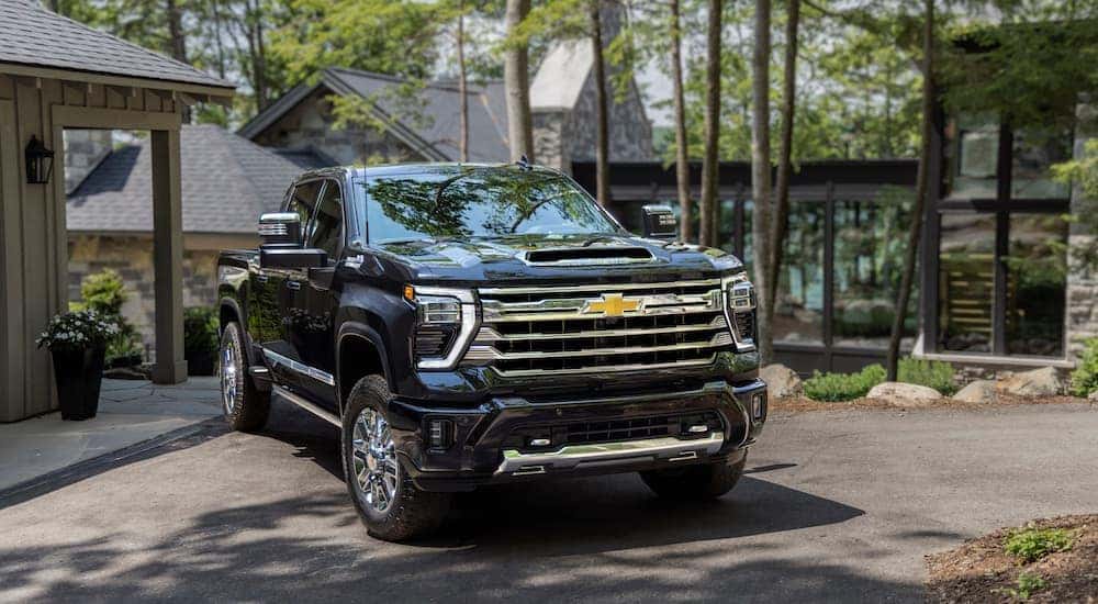 A black 2024 Chevy Silverado 2500 HD High Country is shown from the front at an angle after leaving a dealer that had a Chevy Silverado for sale near Allentown, PA..
