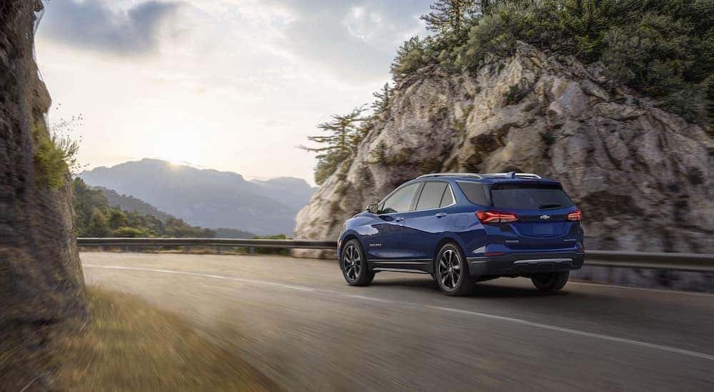 A blue 2023 Chevy Equinox is shown from the rear at an angle after leaving a dealer that has a Chevy Equinox for sale.