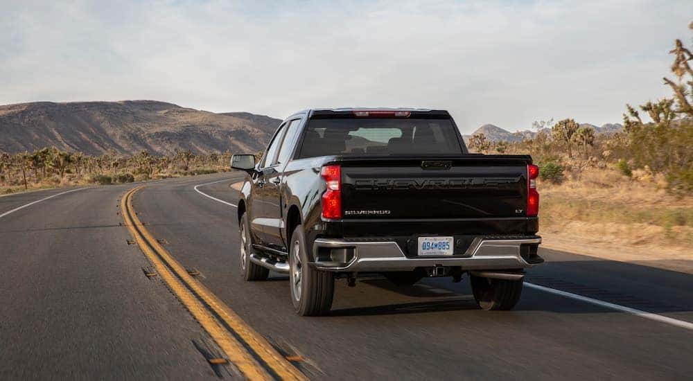 A black 2024 Chevy Silverado 1500 LT is shown from the rear at an angle after leaving a dealer that has a Chevy Silverado for sale near Hellertown, PA.