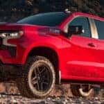 Red 2023 Chevy Silverado 1500 LT Trail Boss on a rocky road