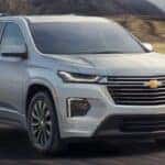 Silver 2023 Chevy Traverse RS driving down a rural road