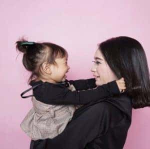 mom-holding-daughter-laughing-together