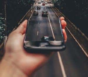 closeup-of-hand-with-phone-with-a-view-of-freeway