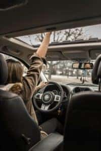person-in-car-sticking-hand-out-of-sun-roof