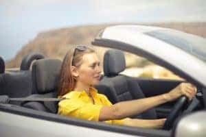 woman-in-yellow-shirt-driving-a-silver-car