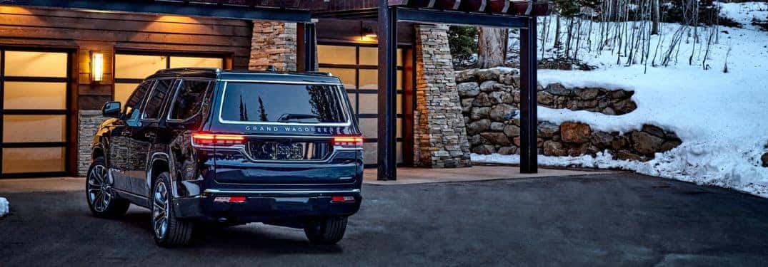 grand wagoneer parked outside a winter cabin