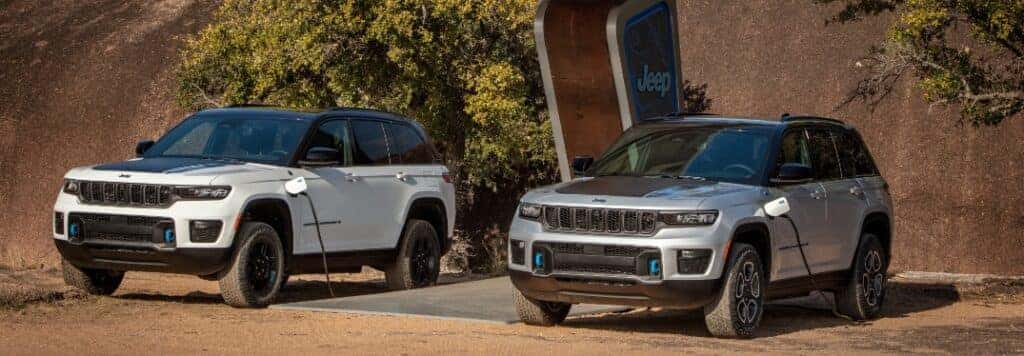 Two 2023 Jeep Wrangler Grand Cherokee 4xe Plugged In to Charge Outside