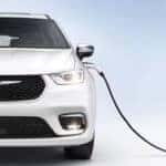 White 2023 Chrysler Pacifica Plug-In Hybrid Front View with Charging Cable Attached