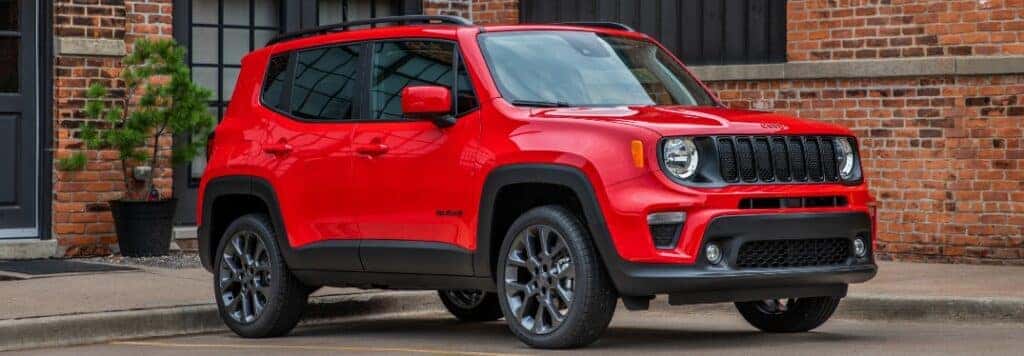 Red 2023 Jeep Renegade Parked in Front of Brick Building