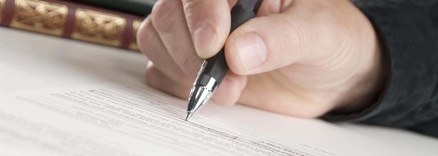 man signing papers for insurance