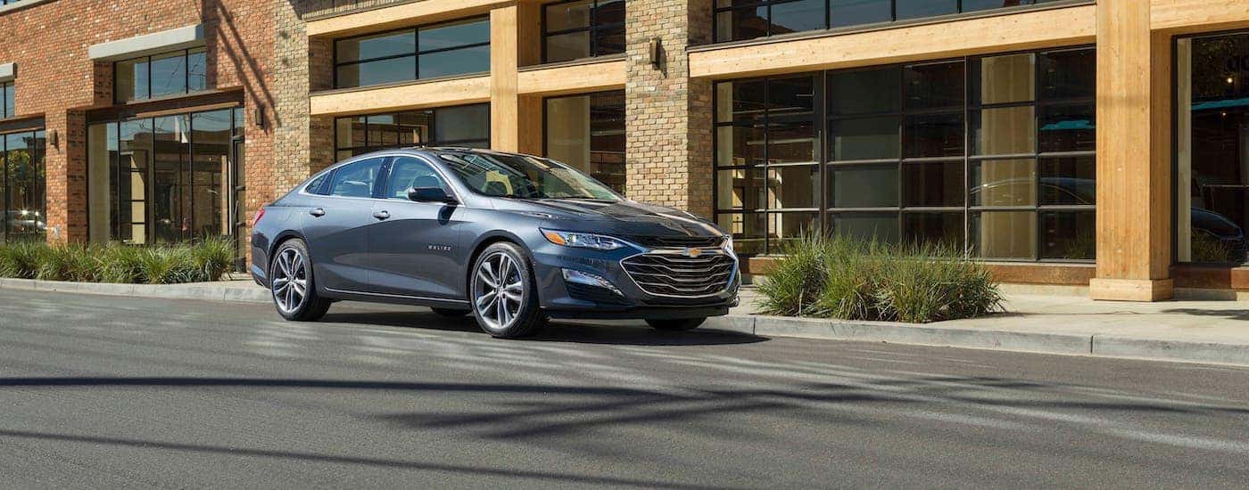A gray 2020 Chevy Malibu is parked in front of a Buford, GA, business.