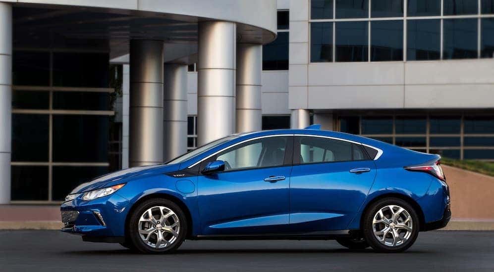 A blue 2018 Chevy Volt, you could find similar models by searching, 'used car dealerships near me', is parked in front of an office building near Buford, GA.