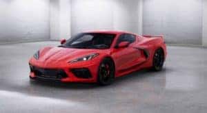 A red 2020 Chevy Corvette is facing left in a white room.