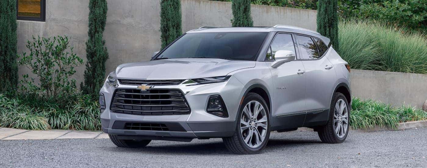A silver 2022 Chevy Blazer is shown from the front parked in front of a modern house after looking at Chevy lease deals.