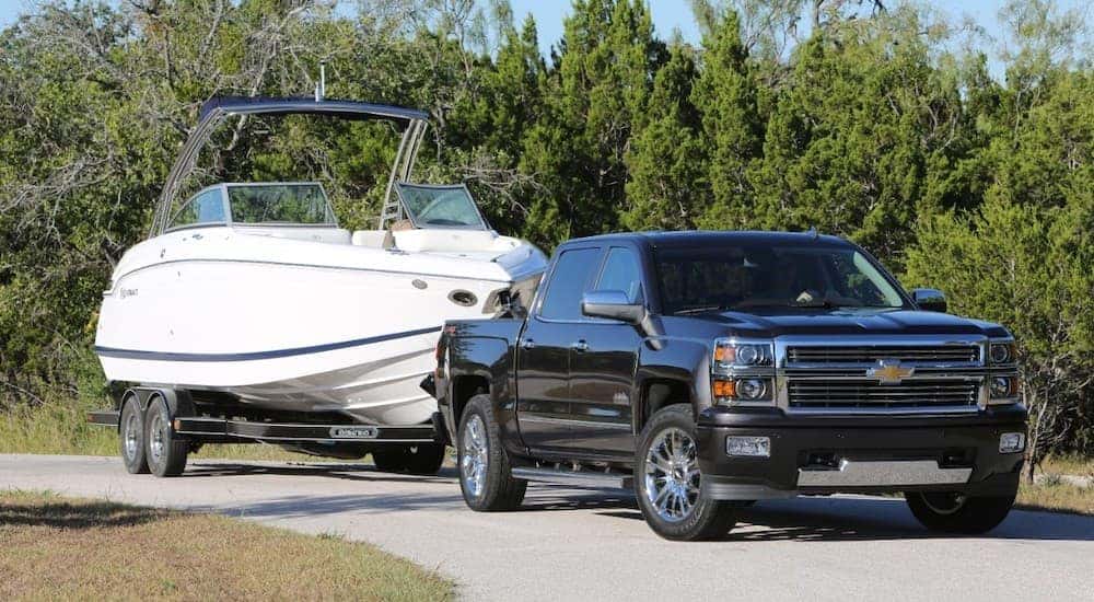 A black 2015 Chevy Silverado 1500 is towing a boat near Buford, GA.