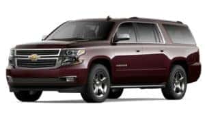A burgundy 2020 Chevy Suburban is facing left.
