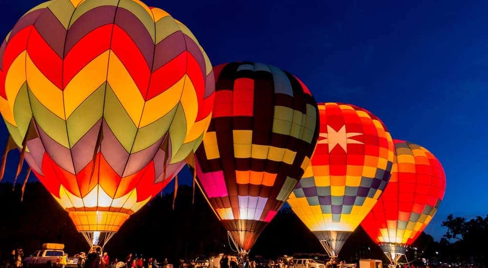 Hot air balloons are lit in a field at night in Atlanta, GA.