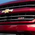 A close up of the front grille of a red 2018 Chevy Silverado 1500 is shown.