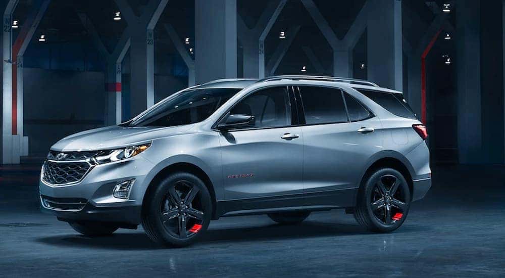A silver 2020 Chevy Equinox Redline edition is parked in a dark lit garage near Buford, GA. i