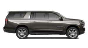 A side view of a grey 2021 Chevy Suburban is facing right.