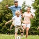 A smiling family is playing in an Atlanta, GA, park.