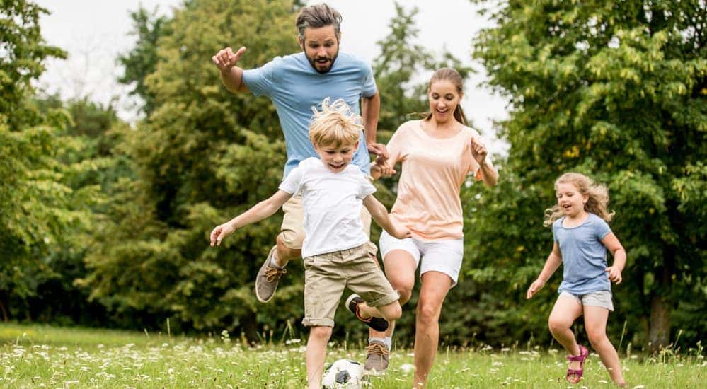 A smiling family is playing in an Atlanta, GA, park. 