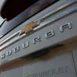 A close up of Suburban in silver is on a Chevy Suburban's tailgate.