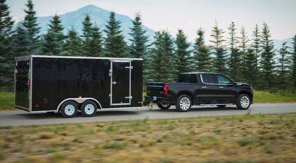 A black 2019 used Chevy Silverado is towing a black enclosed trailer.