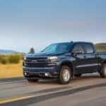 A blue 2019 used Chevy Silverado is driving on a highway near Buford, GA.