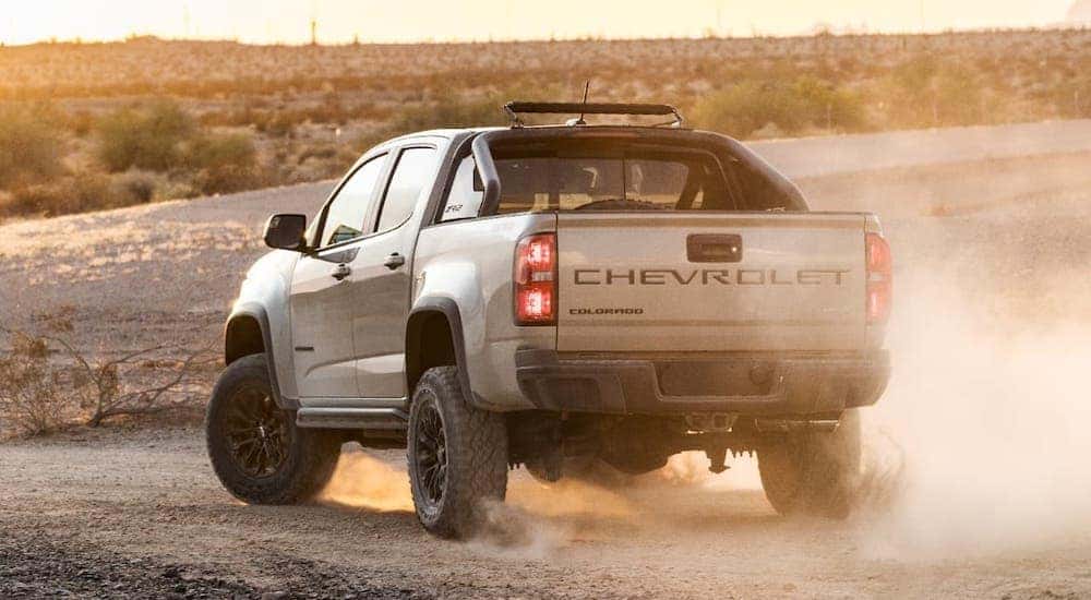 A tan 2021 Chevy Colorado ZR2 is facing away into a desert at dusk.