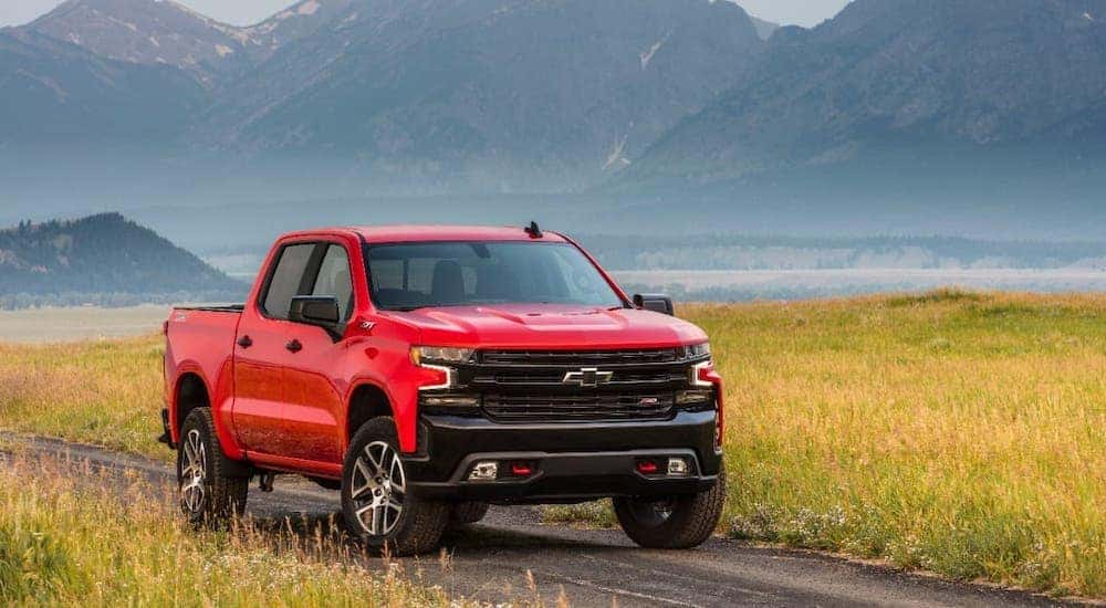 A red 2020 Chevy Silverado LT TrailBoss is parked in front of mountains.