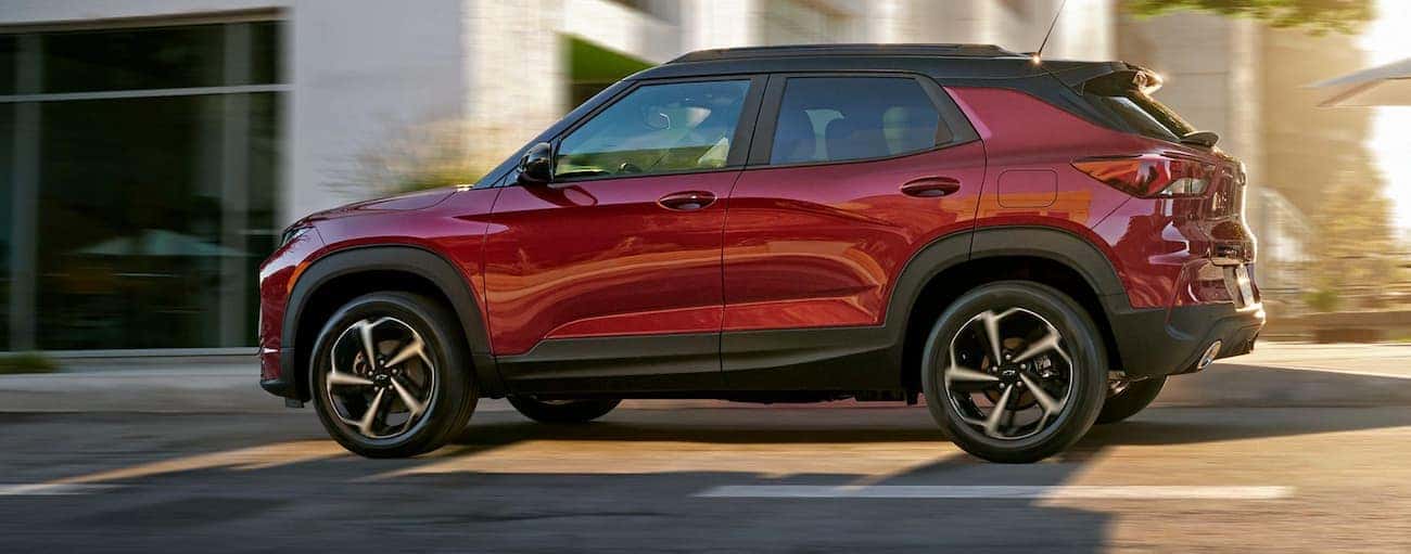 A red 2021 Chevy Trailblazer is driving on a Buford, GA, street after winning the 2021 Chevy Trailblazer vs 2020 Mazda CX-30 comparison.