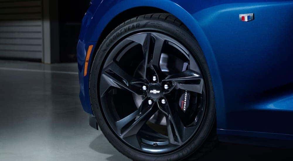 A closeup is shown of the tire on a blue 2019 Chevy Camaro SS, find one at a used car dealership near me.