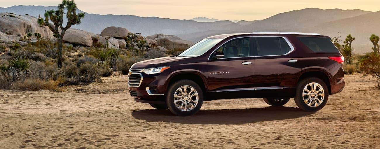 A burgundy 2020 Chevy Traverse is parked in the desert with distant mountains.