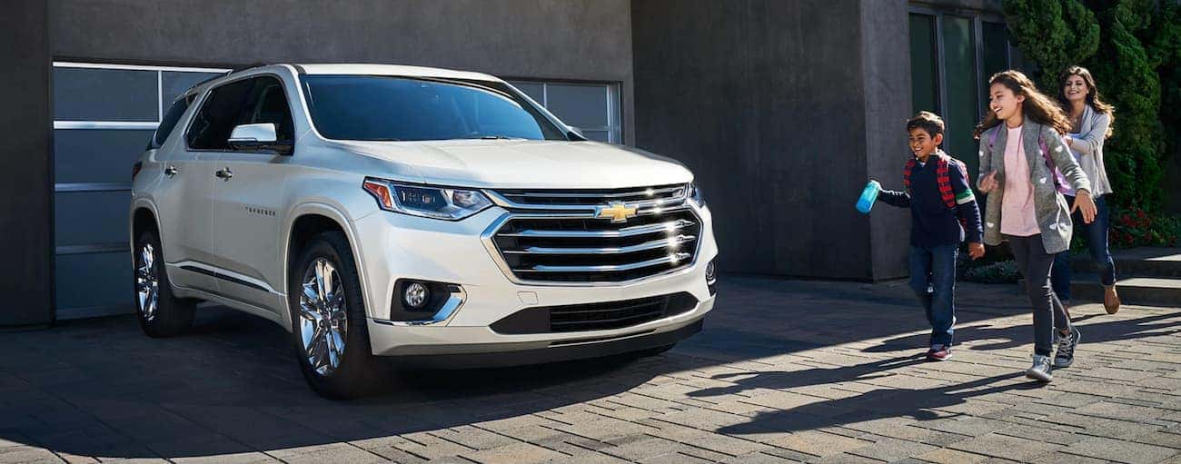 A family is walking to their white 2020 Chevy Traverse parked outside a Buford, GA home.