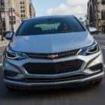 A silver 2017 Chevy Cruze is shown from the front while driving through a city street near Buford, GA.