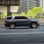 A gray 2019 used Chevy Tahoe is shown from the side driving on a road in Buford, GA.