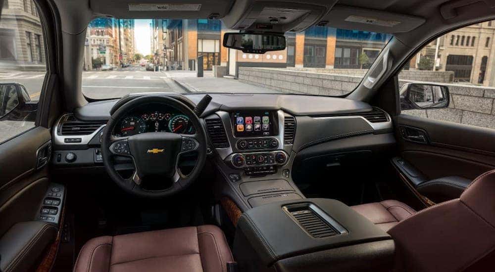 The brown leather seats and dashboard of a 2019 used Chevy Tahoe Premier is shown from the driver's seat.