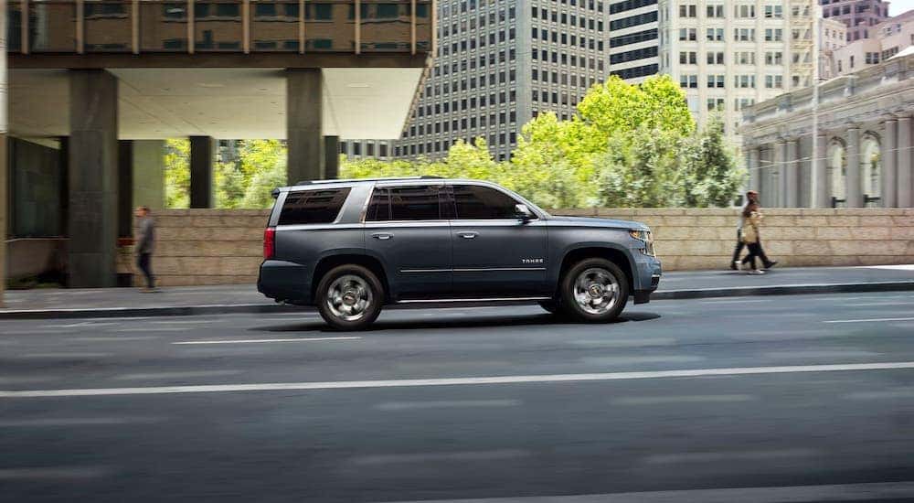 A gray 2019 used Chevy Tahoe is shown from the side driving on a road in Buford, GA.
